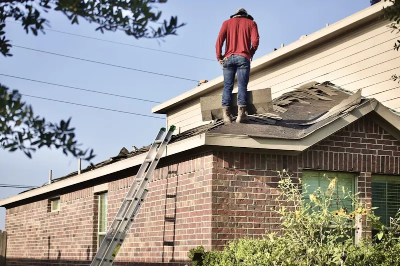 Professional roofer working on a residential roof in University Heights